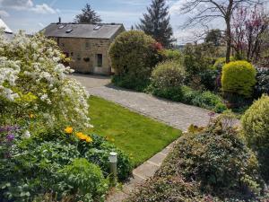 Acorn Cottage, Ashover في Ashover: حديقة امام بيت به ورد