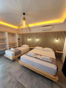 達特恰的住宿－Palamut Butik Otel，一间卧室配有两张床和吊灯。