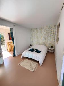 a bedroom with a bed with two shoes on it at Maison cosy au calme proche sanctuaire in Lourdes