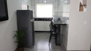a kitchen with a refrigerator and a table and chairs at Casa Completa da Magui - 01 in Pomerode