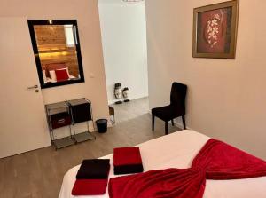 a bedroom with a bed with a red blanket and a chair at Caloura Fire Accommodation in Lagoa