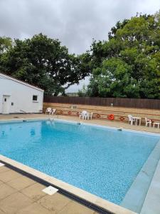 a large swimming pool with white chairs at F14 in Sandown