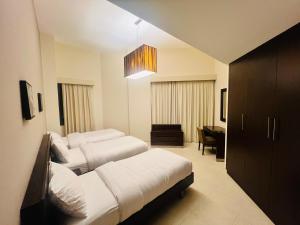 um quarto de hotel com duas camas e um lustre em AlRaef Luxury Apartments no Dubai