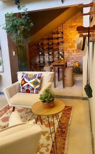 Pousada Boutique das Pedras في مويدا: غرفة معيشة مع أريكة وطاولة
