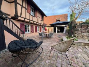 a patio with two chairs and a house at Gîte Trotthus maison familiale avec piscine in Hunawihr