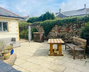 a bench and a table on a patio at Tyluna Cornish Glamping Cabin in Praze an Beeble