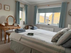 a bedroom with a large bed and a window at Church View Anglesey in Trearddur