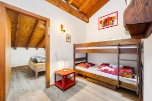 a bedroom with two bunk beds and a table at Duplex cosy aux bains de Saillon in Saillon
