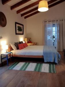 Un dormitorio con una cama grande y una ventana en Jardin de Mucho, en Macharaviaya