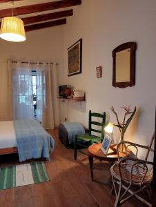 1 dormitorio con 1 cama, 1 mesa y 1 silla en Jardin de Mucho, en Macharaviaya
