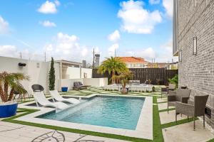 a backyard with a swimming pool and chairs at Pluto Rooftop Villa in New Orleans