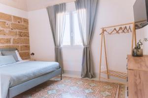 1 dormitorio con cama y ventana grande en Cocci di tufo Appartamenti, en Rilievo
