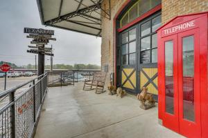 two dogs sitting outside of a building with a red door at Historic Texarkana Studio Rental Walk to Downtown in Texarkana