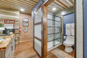 a bathroom with a toilet and a glass door at Historic Texarkana Studio Rental Walk to Downtown in Texarkana +24 photos