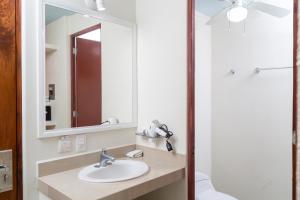 La salle de bains est pourvue d'un lavabo et d'un miroir. dans l'établissement Fabuloso Hotel Las Vegas, à Zihuatanejo