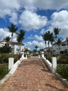 a brick walkway with palm trees and buildings at Apartamento Cadaques Bayahibe in Mata Chalupe