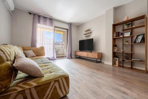 a living room with a couch and a television at Precioso apto, con piscina en puerto de Cambrils, wifi y parking incluido in Cambrils