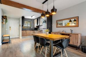 a kitchen and dining room with a wooden table and chairs at Precioso apto, con piscina en puerto de Cambrils, wifi y parking incluido in Cambrils