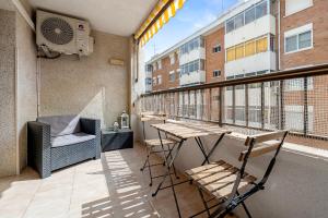 a balcony with a table and chairs and a window at Precioso apto, con piscina en puerto de Cambrils, wifi y parking incluido in Cambrils