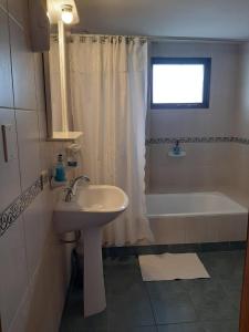 a bathroom with a sink and a bath tub at TZION B&B in Ushuaia