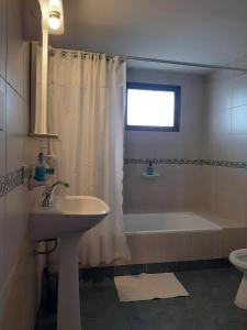 ein Badezimmer mit einem Waschbecken, einer Badewanne und einer Dusche in der Unterkunft TZION B&B in Ushuaia