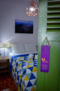 Un dormitorio con una cama con un letrero púrpura. en Velvet Hostal La novena en Santa Ana