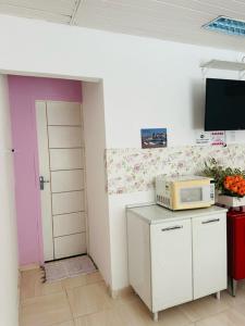 a kitchen with a microwave on top of a counter at Hostel das Flores in Belém
