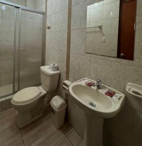 y baño con aseo, lavabo y ducha. en Illari Wari l - Hotel Sauna, en Ayacucho