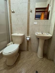 a bathroom with a toilet and a sink at Illari Wari l - Hotel Sauna in Ayacucho