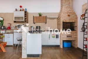 uma cozinha com electrodomésticos brancos e uma parede de tijolos em Casa com piscina e mesa de sinuca em Itupeva em Itupeva