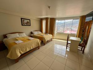 a hotel room with two beds and a window at Illari Wari l - Hotel Sauna in Ayacucho