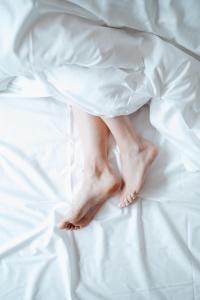 kobieta w białej sukience leżąca na łóżku w obiekcie Hotel Janssen w mieście Valkenburg