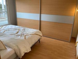 een slaapkamer met een bed en een houten muur bij Neeravert in Londerzeel