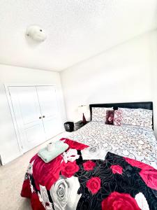 1 dormitorio con 1 cama blanca y negra con rosas rojas en Bellhaven Beautiful Home, en Brampton