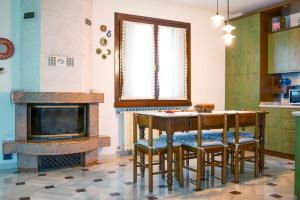 a kitchen with a table and chairs and a fireplace at HOLIDAY HOUSE LE COCCINELLE in Salò