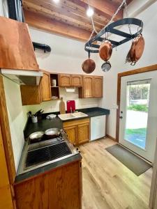 a kitchen with a sink and a stove top oven at Cedar Cabin Near Silverwood in Spirit Lake