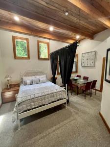 a bedroom with a bed and a dining room with a table at Cedar Cabin Near Silverwood in Spirit Lake