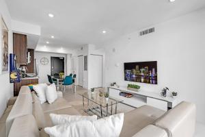 een witte woonkamer met een bank en een tafel bij Chic 3 Bed Retreat Mins Brickell With Free Parking in Miami +38 foto's