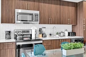 een keuken met een fornuis en een magnetron bij Chic 3 Bed Retreat Mins Brickell With Free Parking in Miami