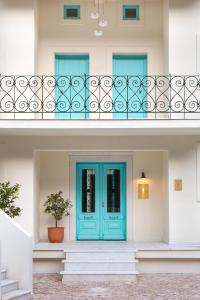 Avlákia的住宿－Aegean Stories pelagos suites，一座带蓝色门和栅栏的房子