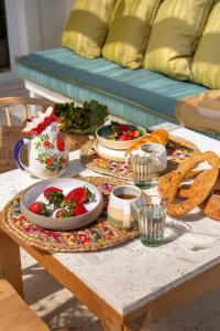 a table with a plate of food on it at Aegean Stories pelagos suites in Avlákia