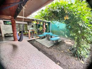 a patio with two blue benches and a swing at Rio Danta Hostel in Fortuna