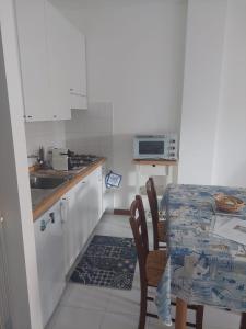 a small kitchen with a table and a sink at Monolocale La Conchiglia in Sestri Levante