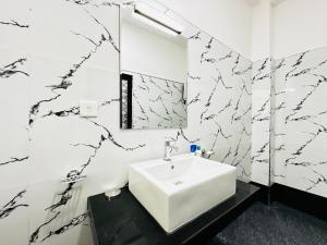 a bathroom with a white sink and black and white wallpaper at Large 4 Bedroom Spacious Apartment in Nugegoda, Colombo in Nugegoda +44 photos