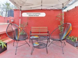 patio z 2 krzesłami, stołem i ławką w obiekcie HOSTAL ROMA w mieście Meksyk