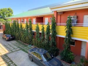 a car parked in front of a building with trees at Jocanai Residences Studio C in Lusong