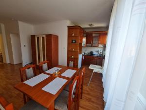 une salle à manger avec une table et une cuisine dans l'établissement Fischer Apartman 3, à Hajdúszoboszló