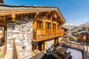 a log house with a balcony and a deck at Chalet Gypaete - Chalets pour 14 Personnes 881 in Tignes
