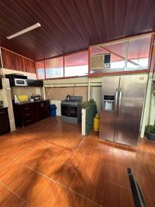 cocina grande con suelo de madera y electrodomésticos de acero inoxidable en Cozy House in Santa Ana, en Santa Ana