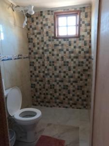 La salle de bains est pourvue de toilettes et d'une fenêtre. dans l'établissement Casarão hostel, à Arraial do Cabo